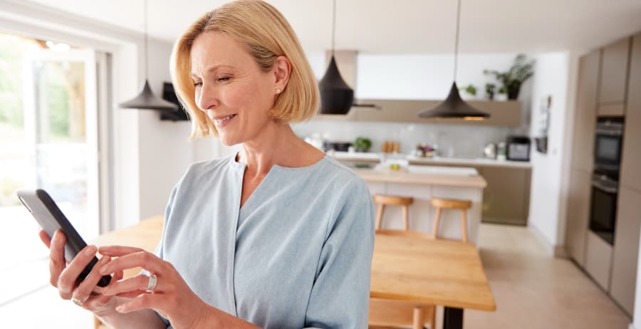 Homeowner holding a mobile device in a stylish home
